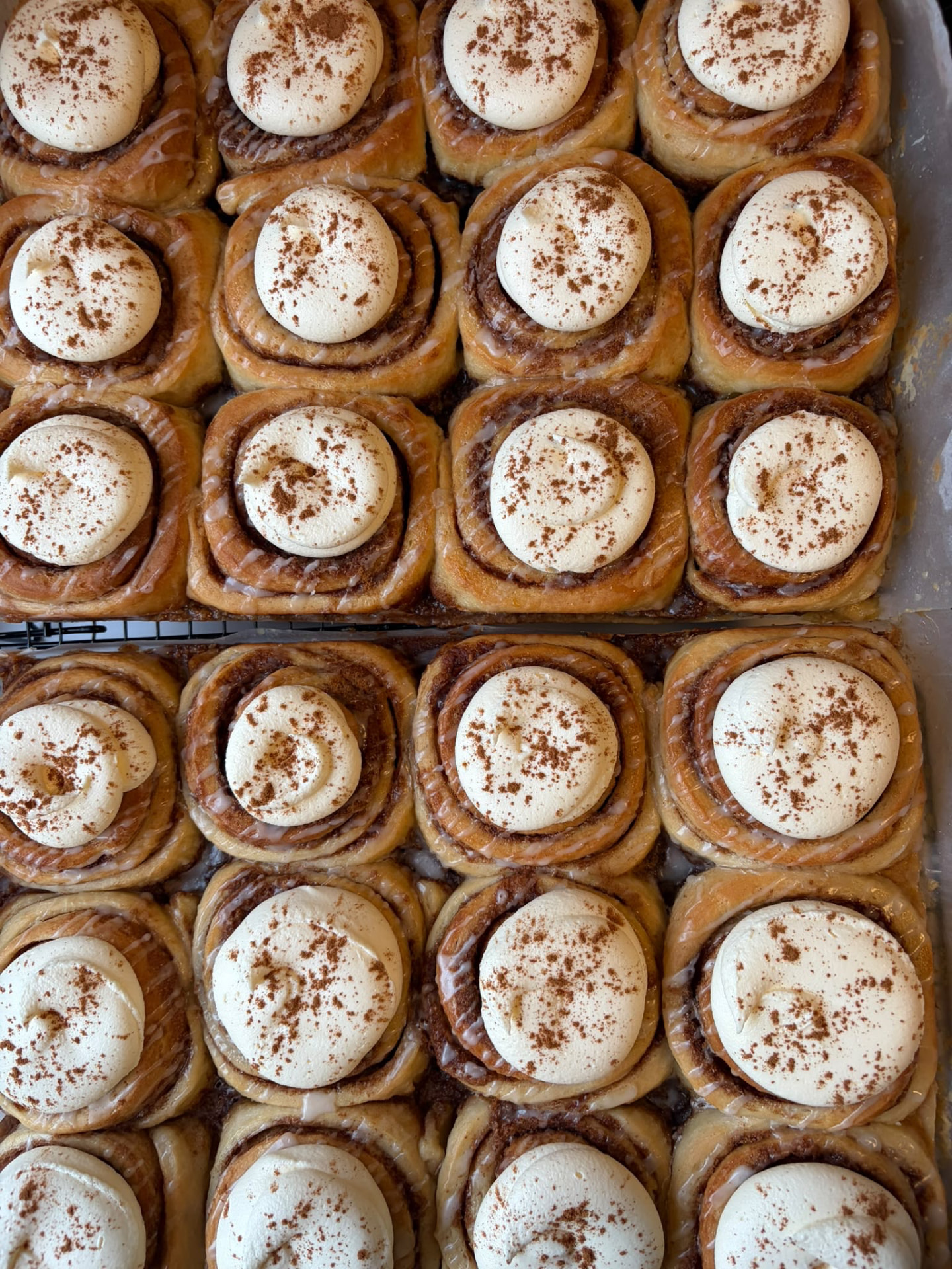 Tray of freshly baked cinnamon buns with cream cheese frosting